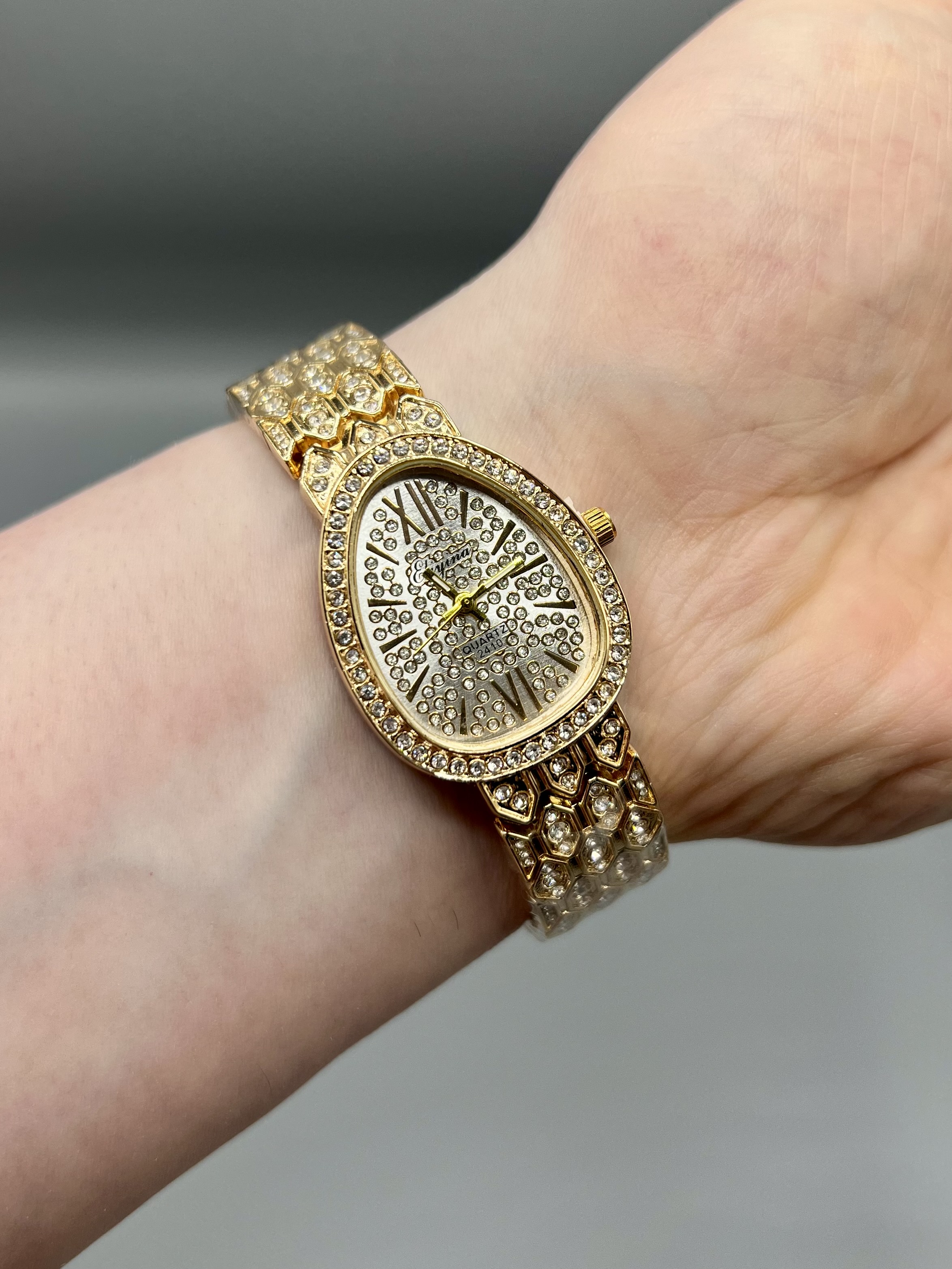 ساعت زنانه الینا الهام گرفته از بولگاری با قاب بیضی نگین دار و بند طلایی لوکس