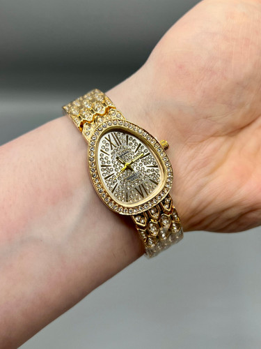 ساعت زنانه الینا الهام گرفته از بولگاری با قاب بیضی نگین دار و بند طلایی لوکس