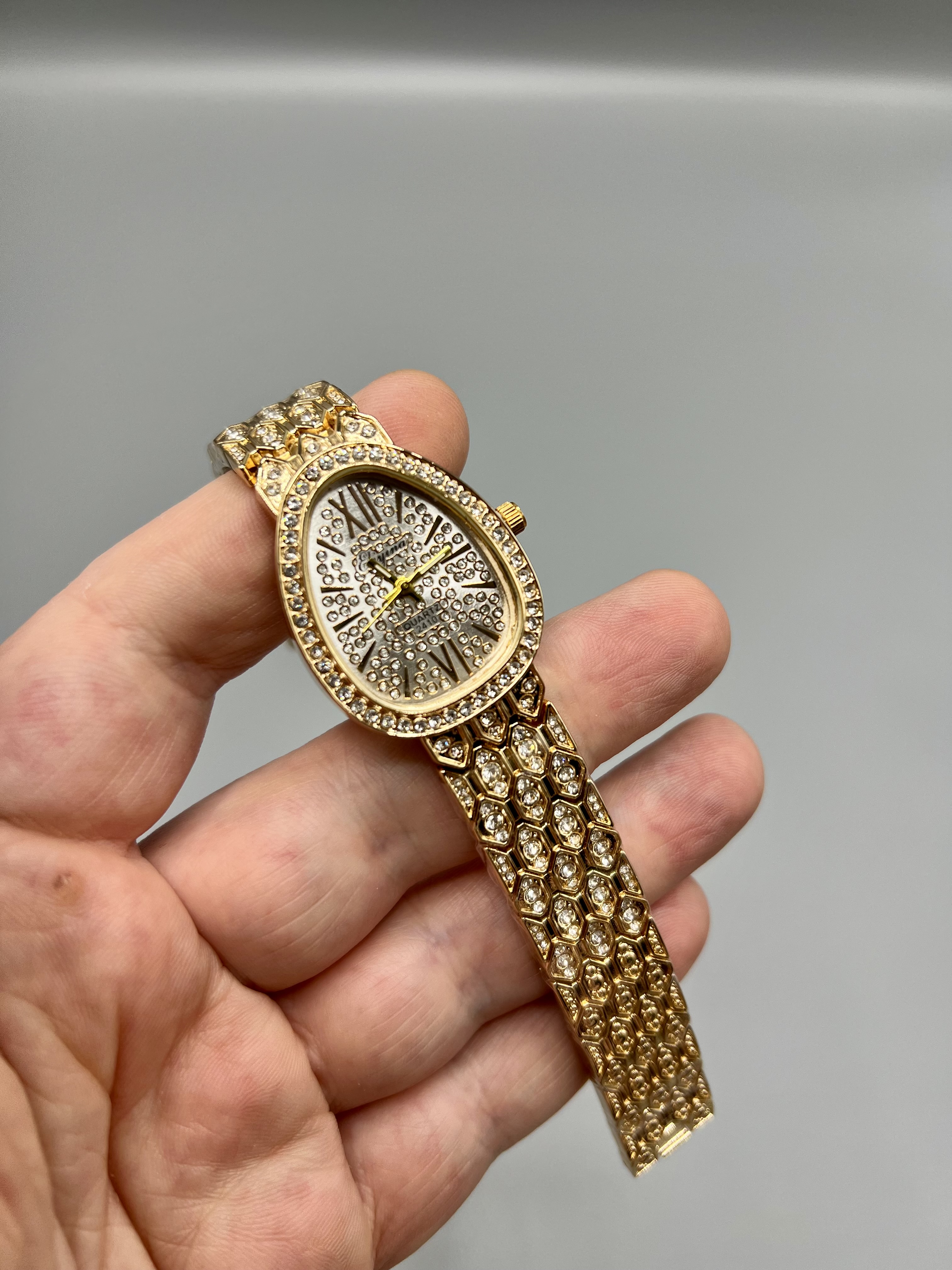 ساعت زنانه الینا الهام گرفته از بولگاری با قاب بیضی نگین دار و بندطلایی لوکس